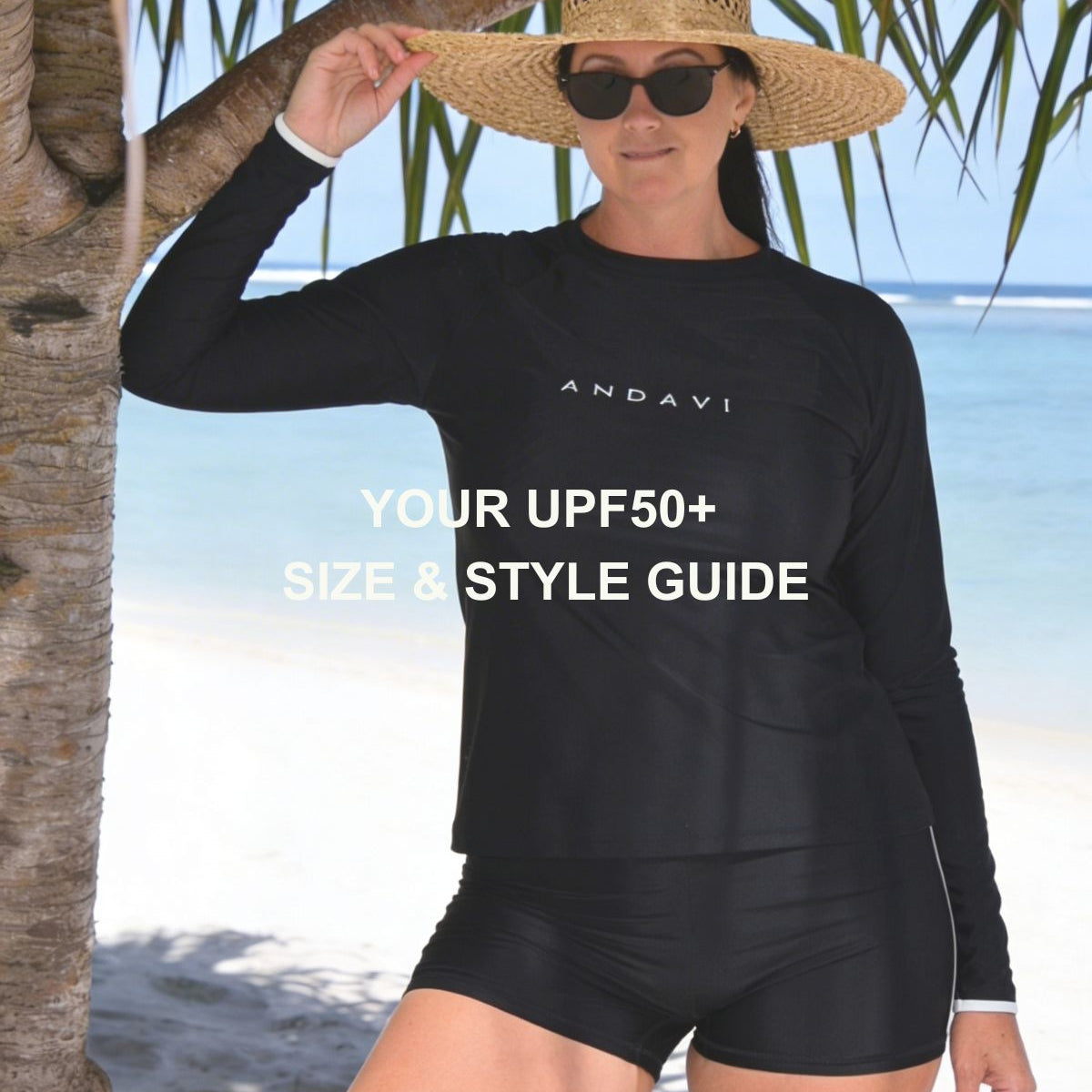 Woman wearing a black long-sleeve top and shorts with 'ANDAVI' branding on a beach.