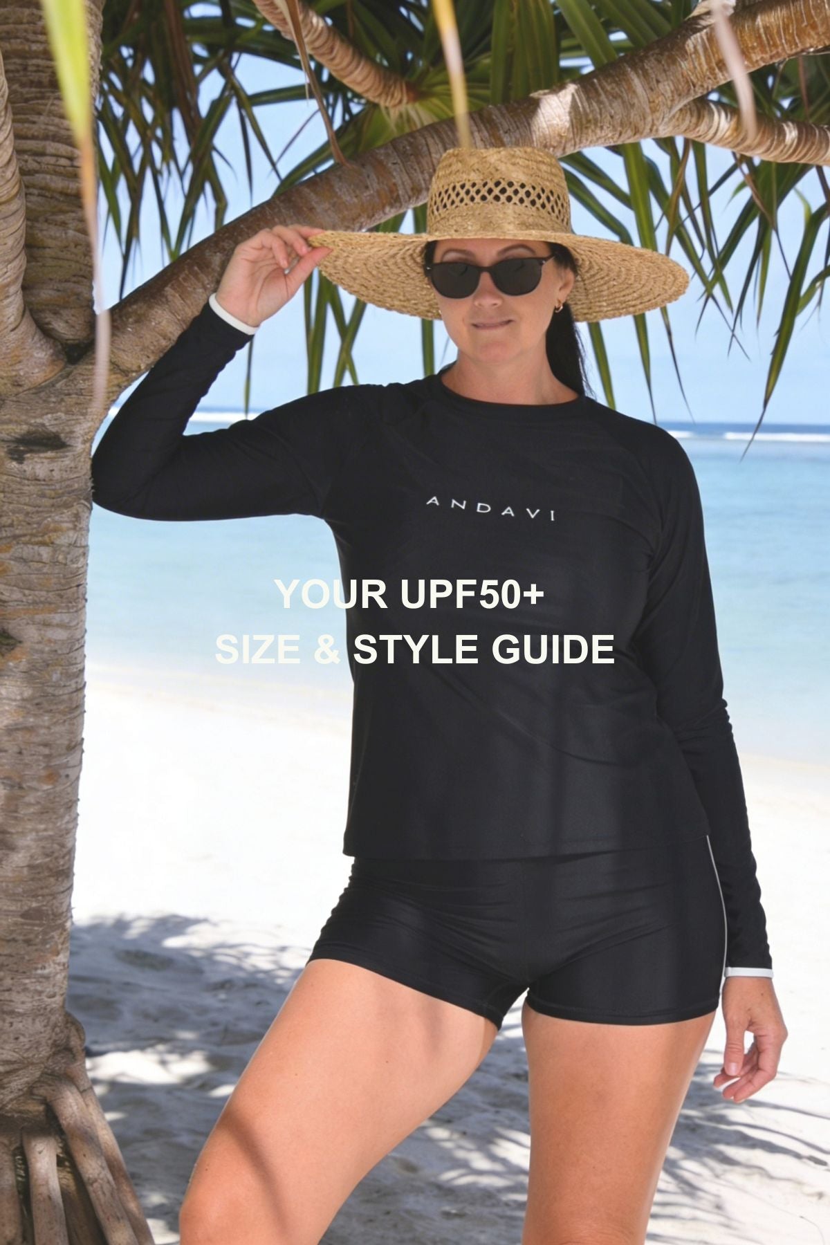 Woman wearing a black long-sleeve top and shorts with 'ANDAVI' branding on a beach.