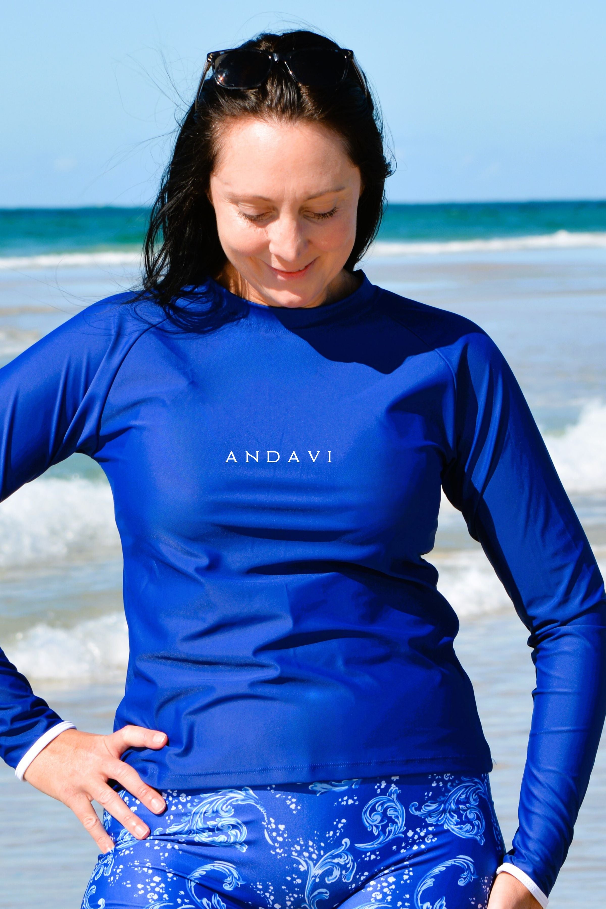 Woman wearing a blue ANDAVI shirt on a beach