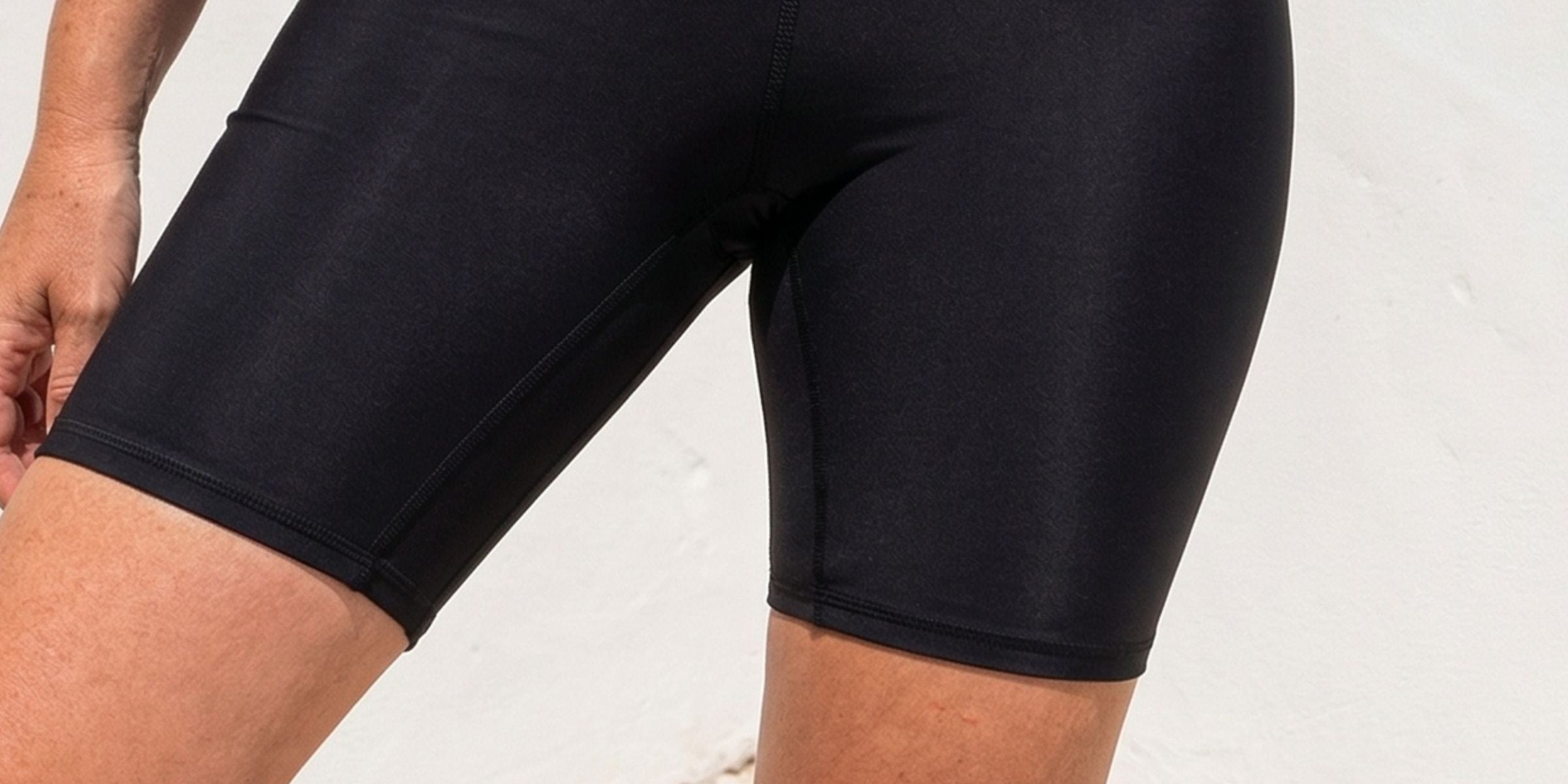 Person wearing black compression shorts with text indicating features on a light background