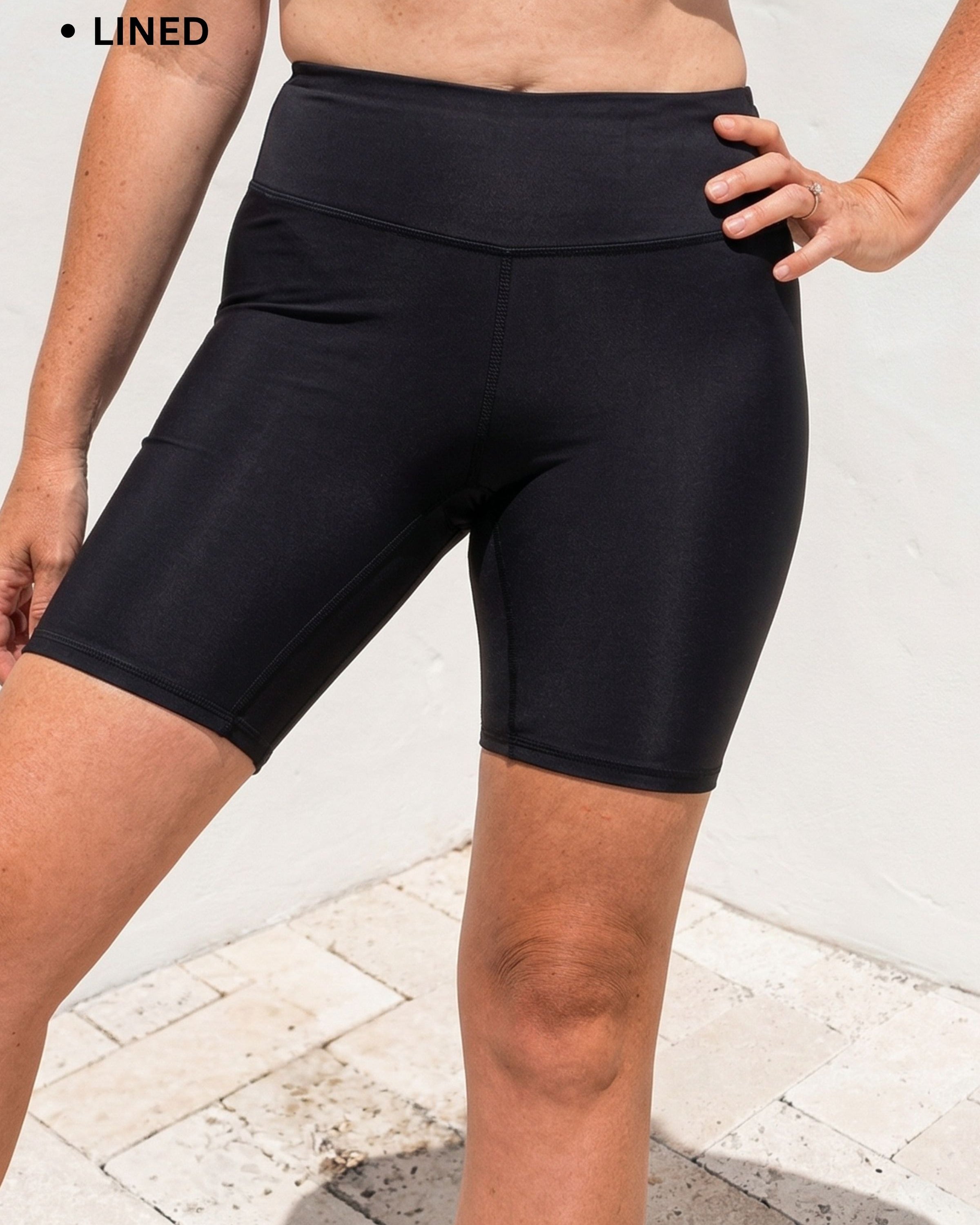 Person wearing black compression shorts with text indicating features on a light background