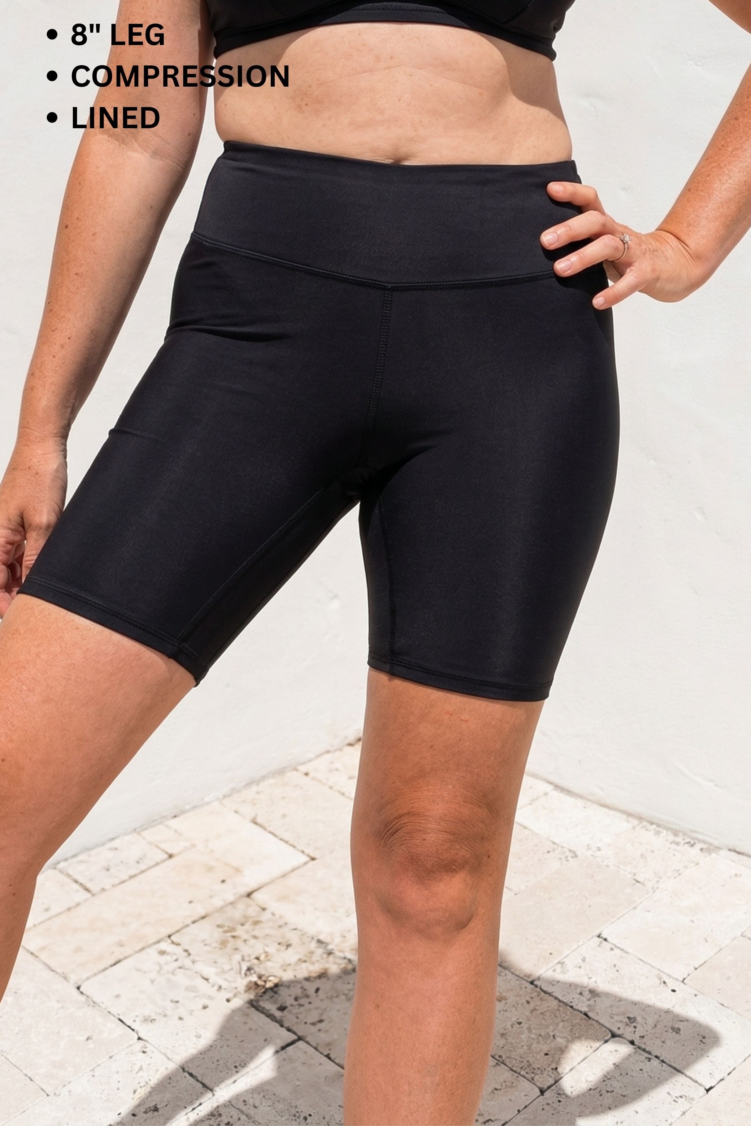 Person wearing black compression shorts with text indicating features on a light background