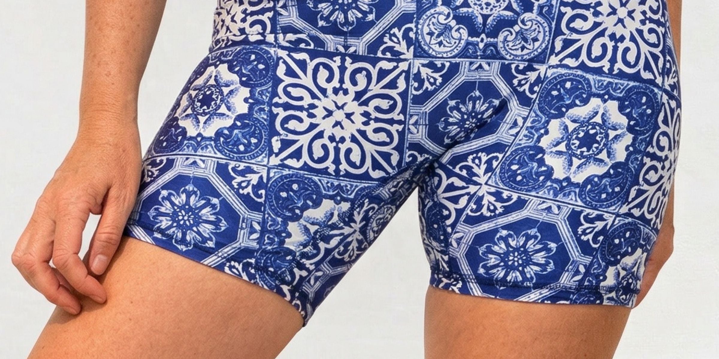 Blue patterned shorts worn by a person on a white background