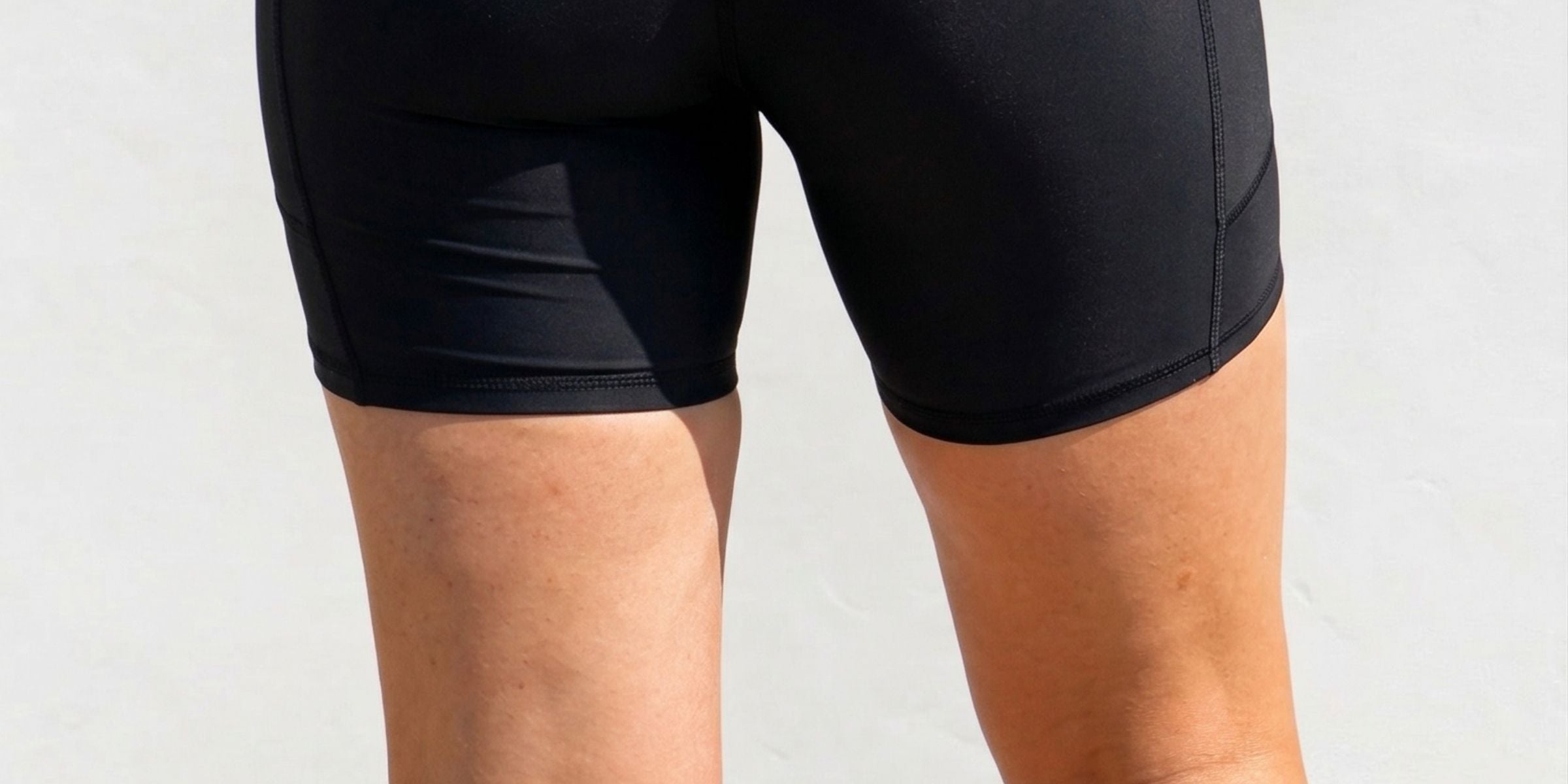 Black athletic shorts with features listed on a white background