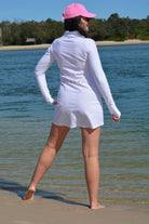 women at the beach wearing andavi swim pink cap and andavi swim long sleeve white swim active dress cover up