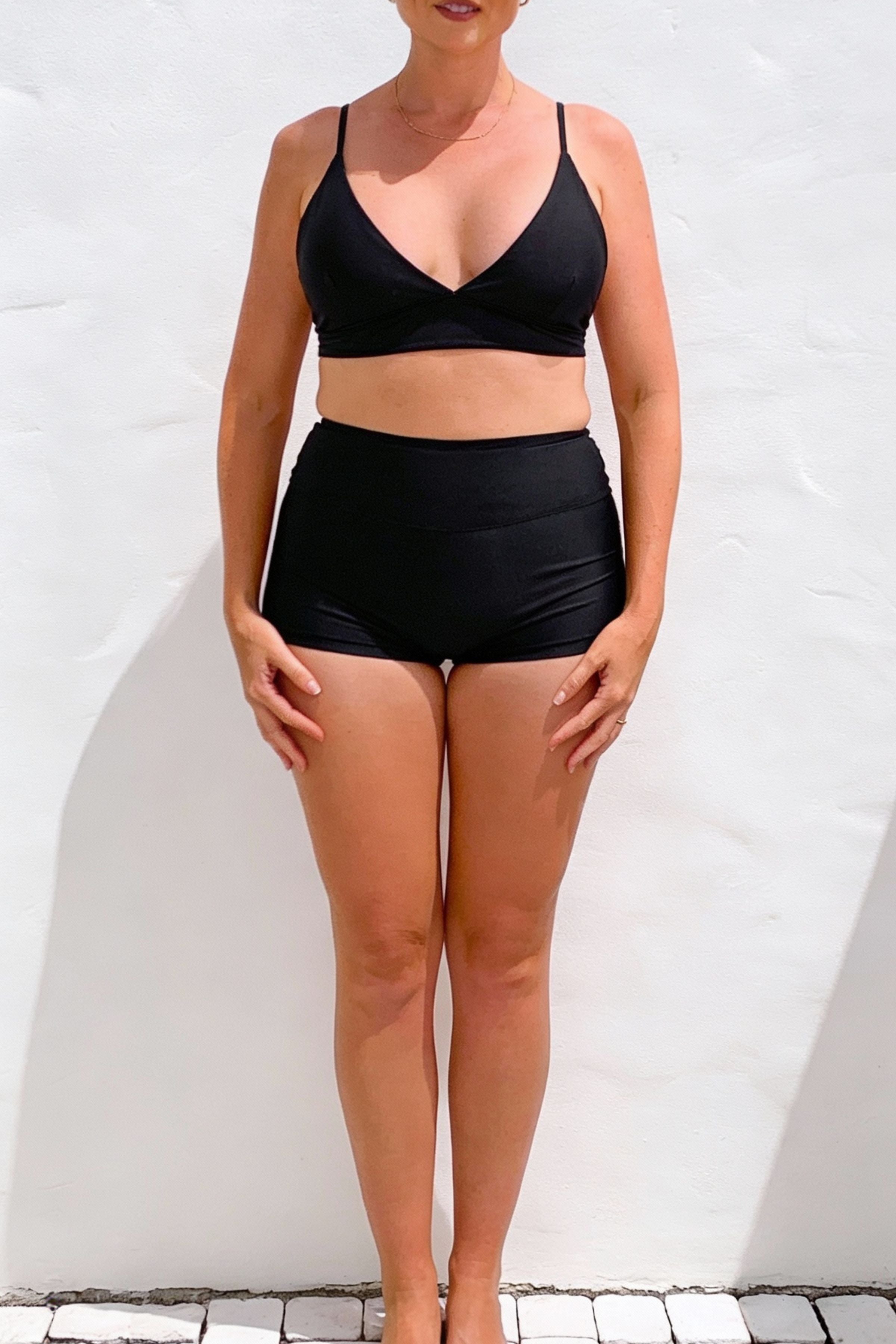 Person wearing a black bikini set against a white background