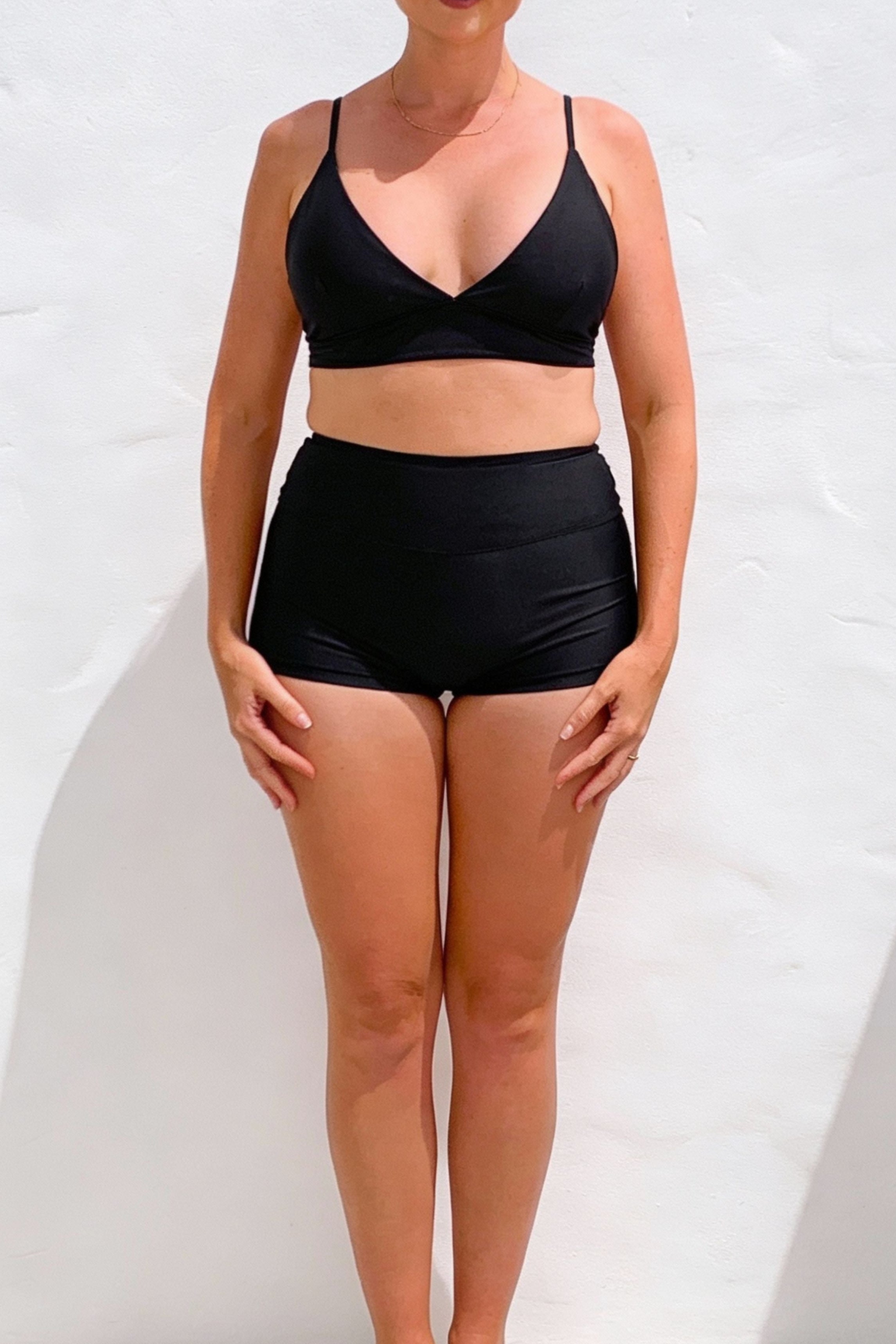 Person wearing a black bikini set against a white background