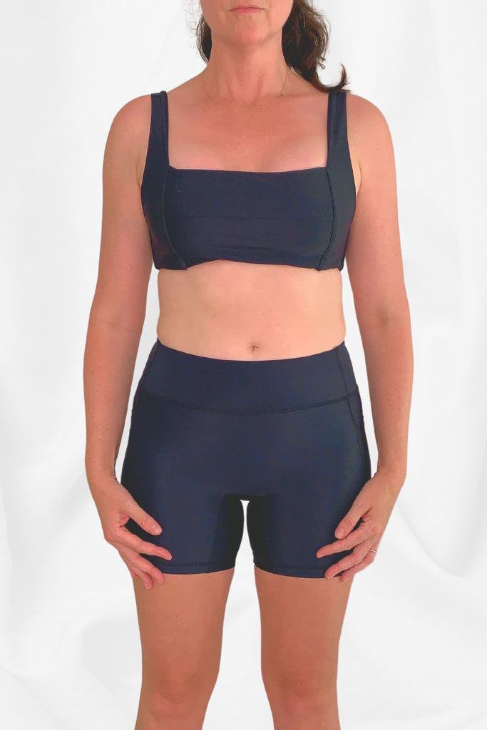 model facing front on wearing square back bikini top and black swim active bike shorts
