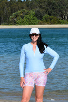 women wearing light blue long sleeve rash guard and floral bike shorts