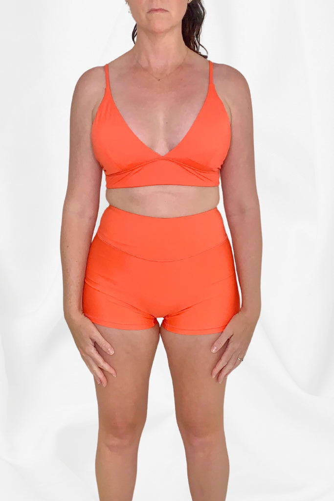 women wearing coral triangle bikini top and swim shorts