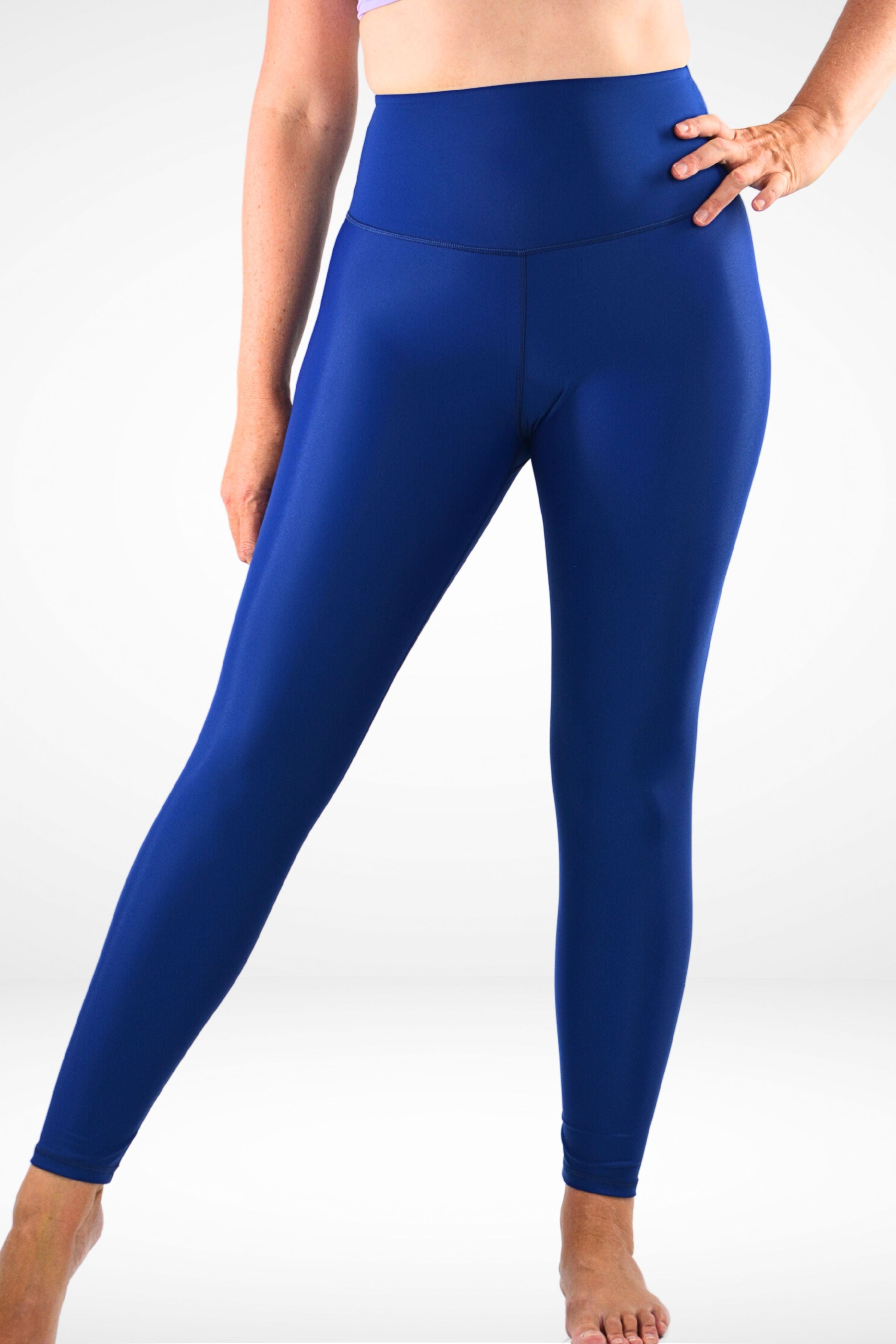 A model wearing a deep blue, high-rise, full-length swim active legging.