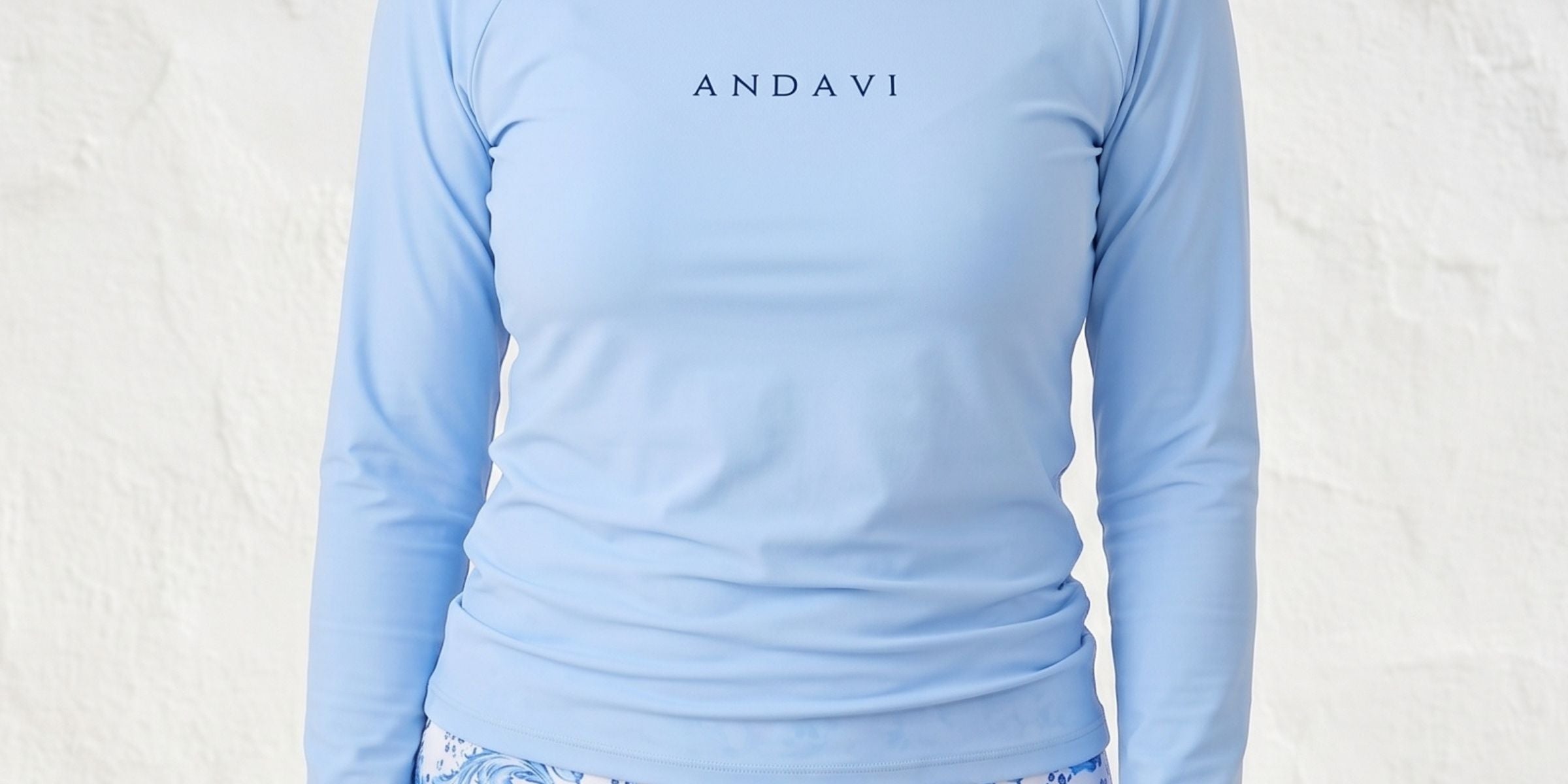 women wearing light blue andavi rash guard and blue and white swim shorts