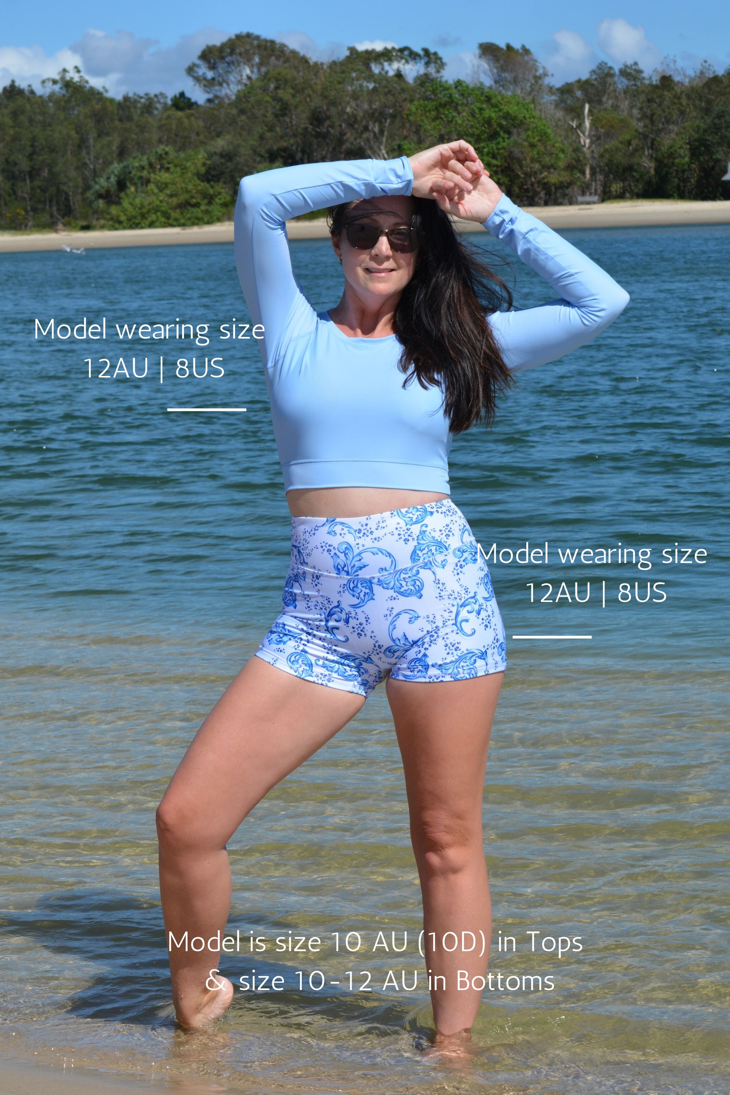 model on the beach wearing andavi swim light blue long sleeve upf50+ crop top and swim active shorties in white and blue print