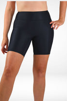 Black swim shorts worn by a person on a white background