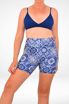 model wearing navy blue triangle bikini top and navy blue and white geometric print swim active shorts