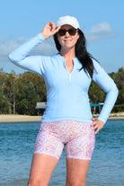 women on the beach wearing light blue rash guard and floral swim active bike shorts