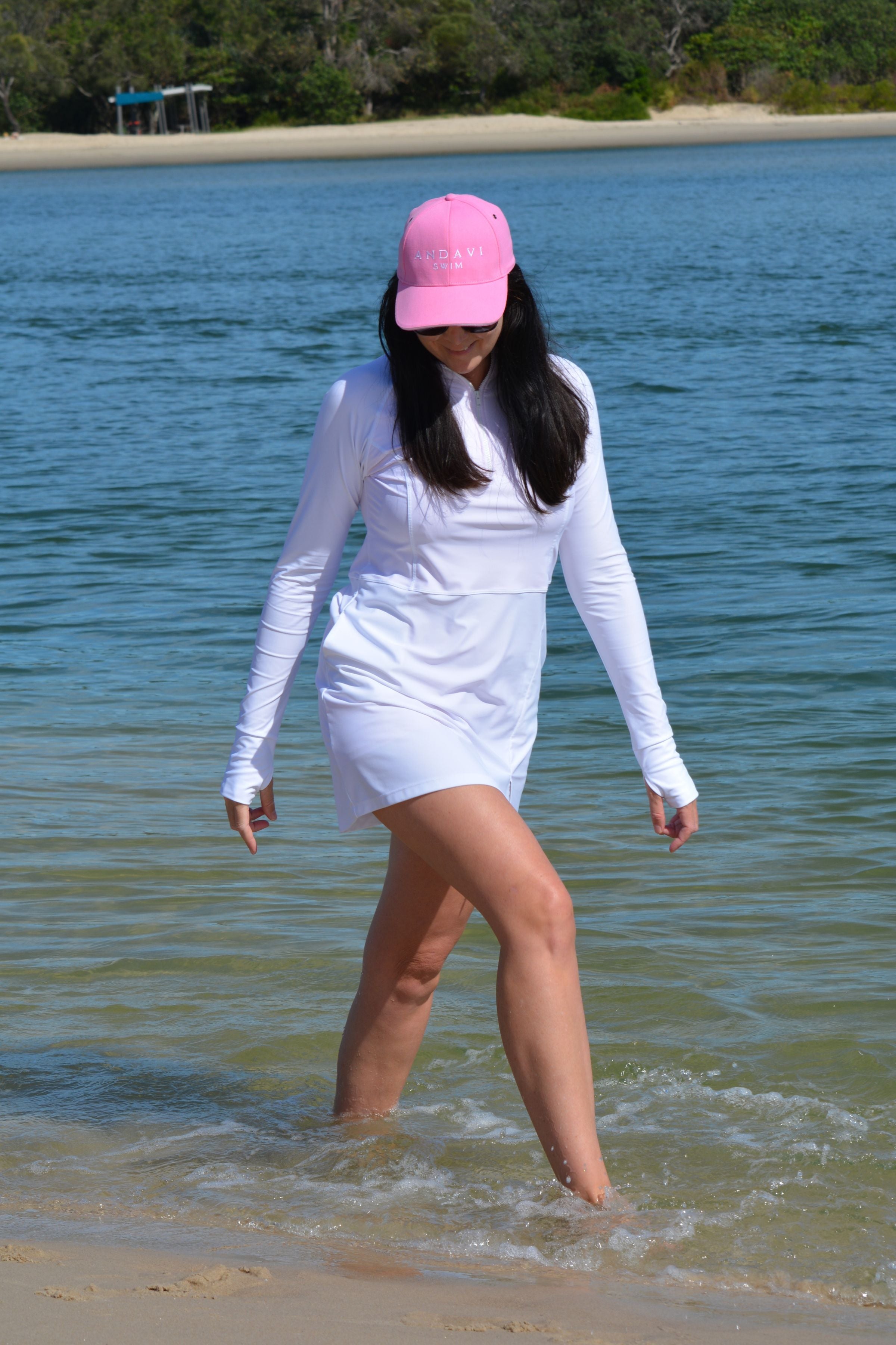 women at the beach wearing andavi swim pink cap and andavi swim long sleeve white swim active dress cover up