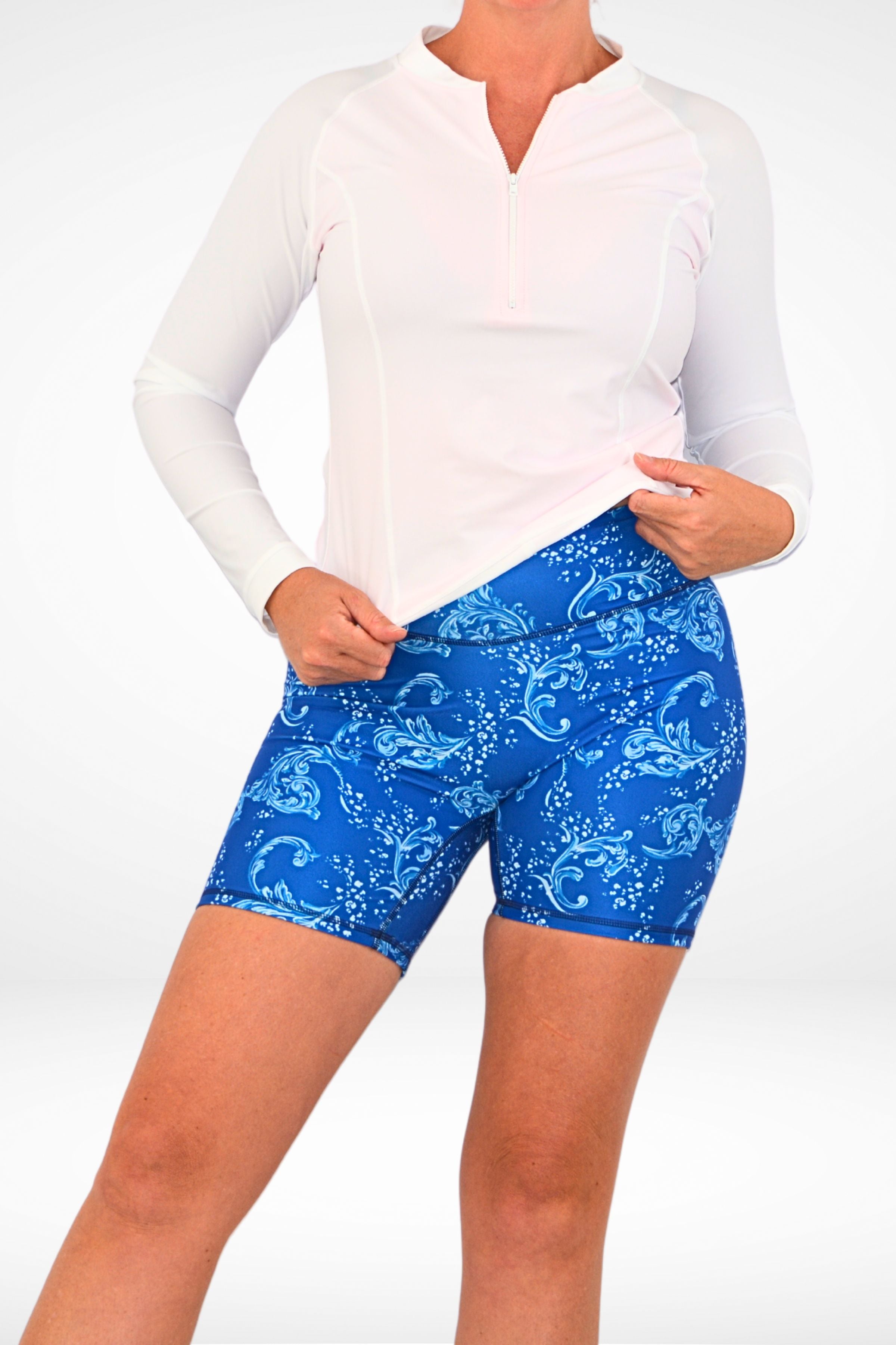 model wearing andavi white long sleeve upf50 rash guard and blue and white swim shorts
