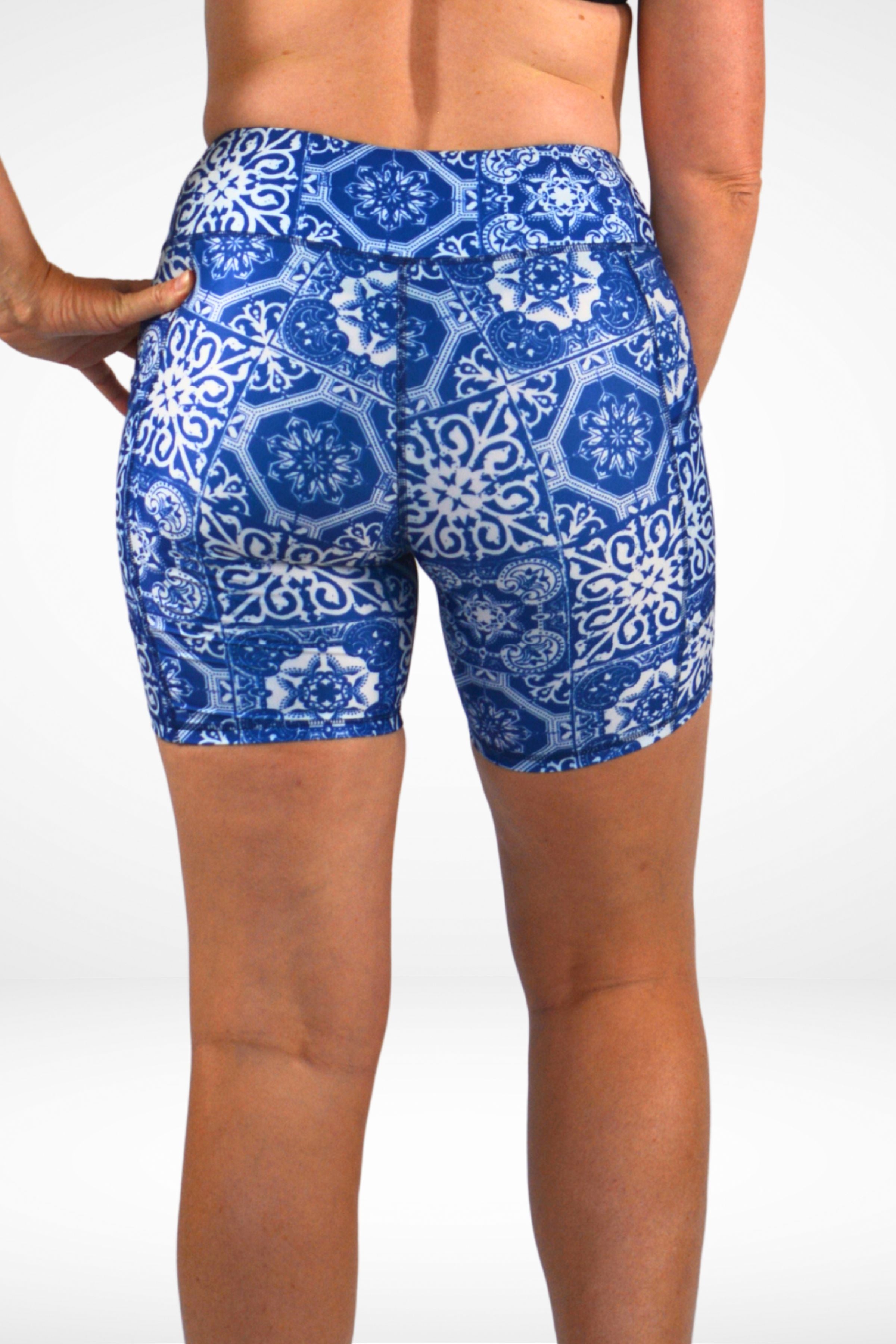 Blue patterned shorts worn by a person on a white background