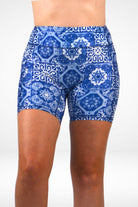 Blue and white patterned shorts worn by a person on a white background