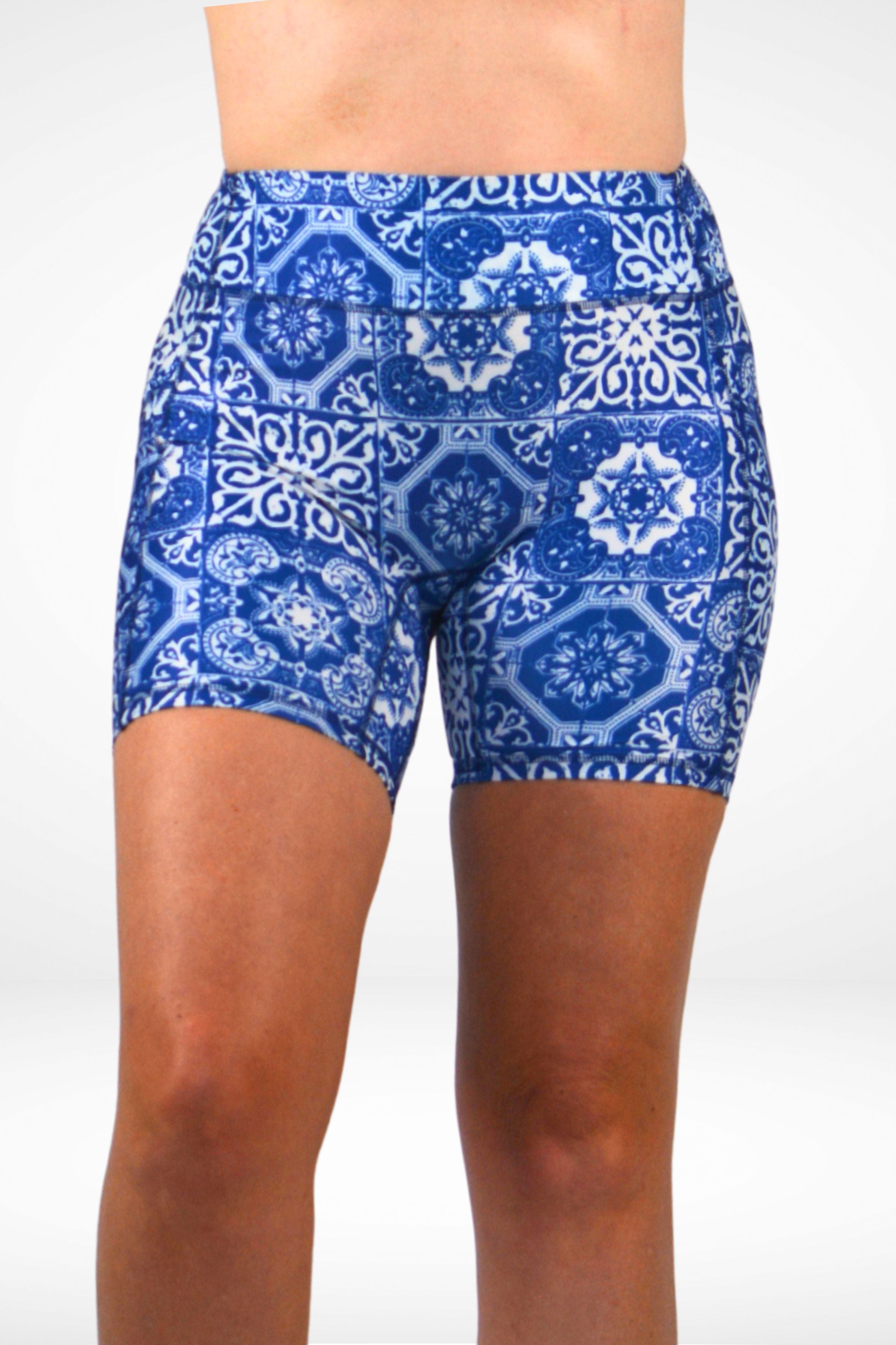 Blue and white patterned shorts worn by a person on a white background
