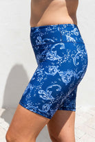 Blue patterned shorts worn by a person on a light background