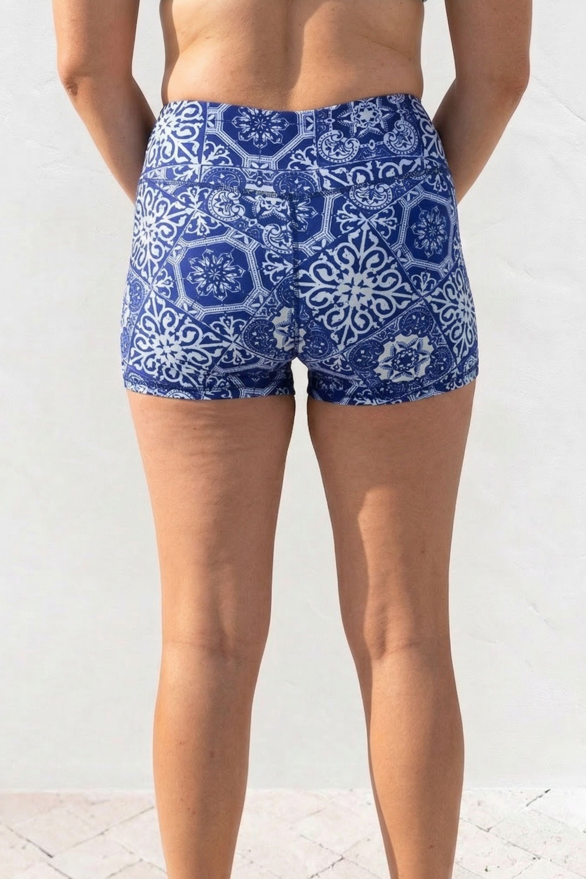 Blue patterned shorts worn by a person on a white background