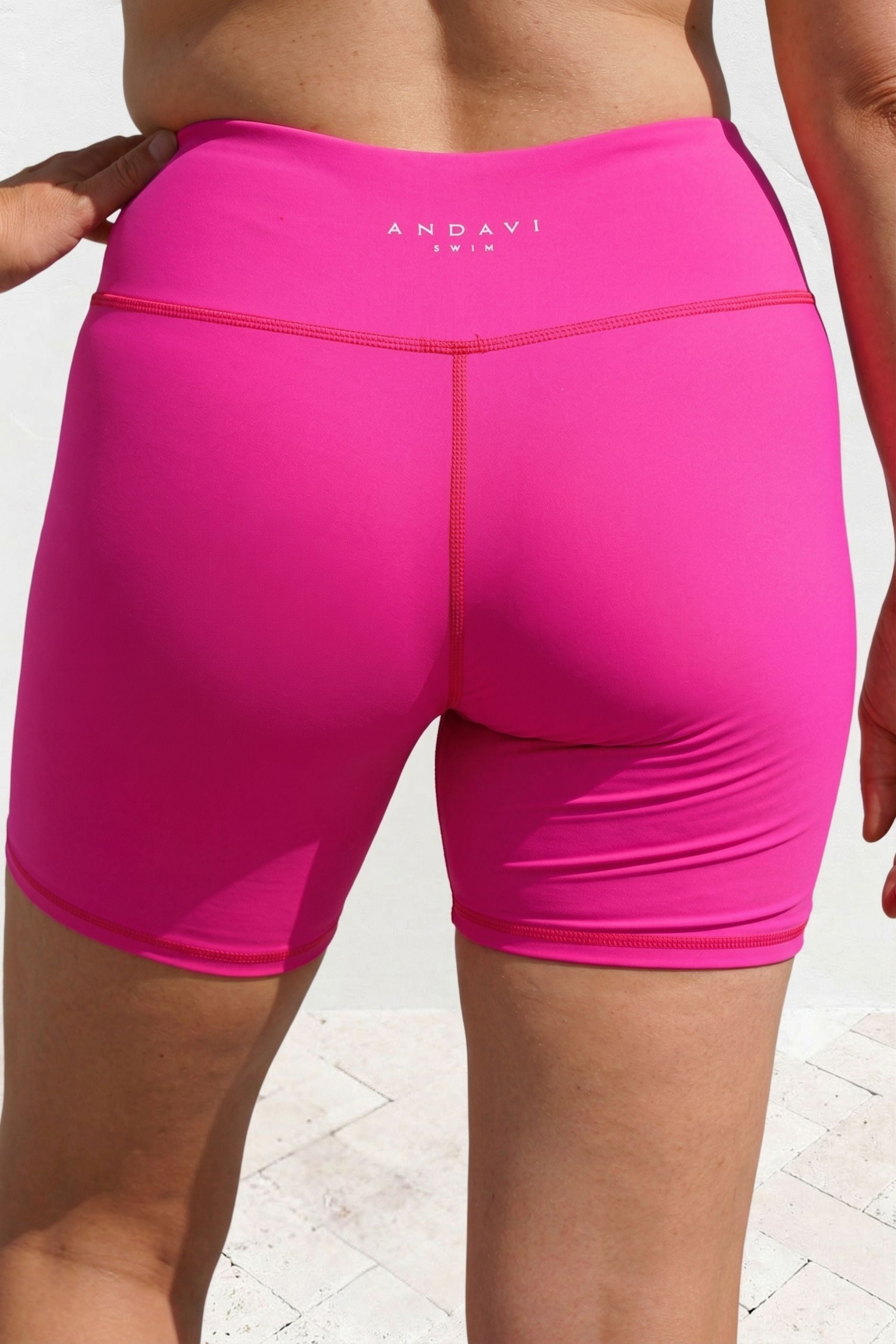 Pink athletic shorts with 'Andavi' branding on a light background