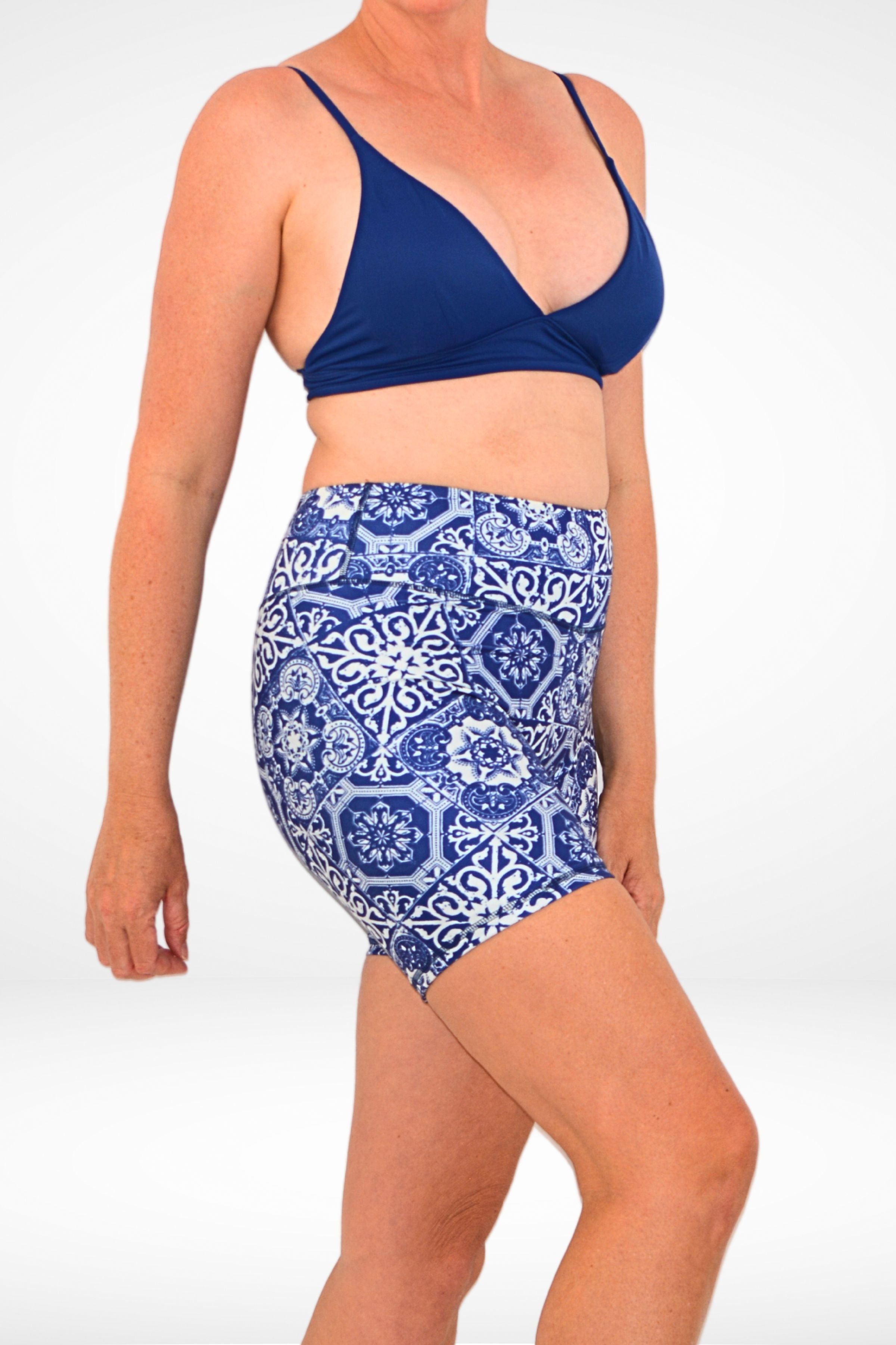 model wearing andavi navy blue and white geometric print compression swim shorts and navy blue triangle bikini top