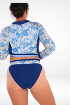 women wearing andavi swim navy blue high rise bikini bottom and navy blue and white print long sleeve rash guard