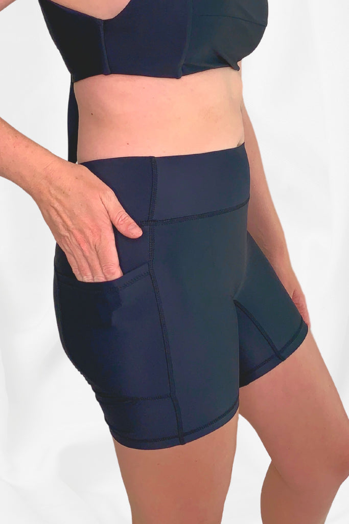 model side view wearing black swim bike shorts with side pocket