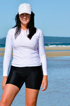 women wearing long leg black swim shorts and white long sleeve rash guard