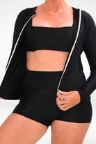 women wearing unzipped black rash guard with square neck bikini top and black swim shorts