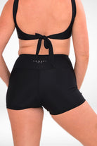 back view of a women wearing black tie up bikini top and black andavi swim active shorties