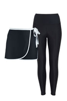 Black swim active wrap skirt and swim leggings set on a white background