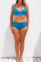 Woman wearing a blue bikini against a white background