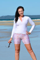 women on the beach wearing floral swim active bike shorts and white long sleeve rash guard