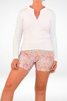 model wearing andavi white long sleeve upf50 rash guard and longer leg swim active bike short floral print