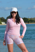 women wearing light link long sleeve rash guard and floral bike pants at the beach
