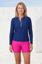 women wearing long sleeve andavi rash guard and pink swim shorts 