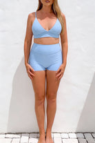 Woman wearing a light blue bikini set against a white background