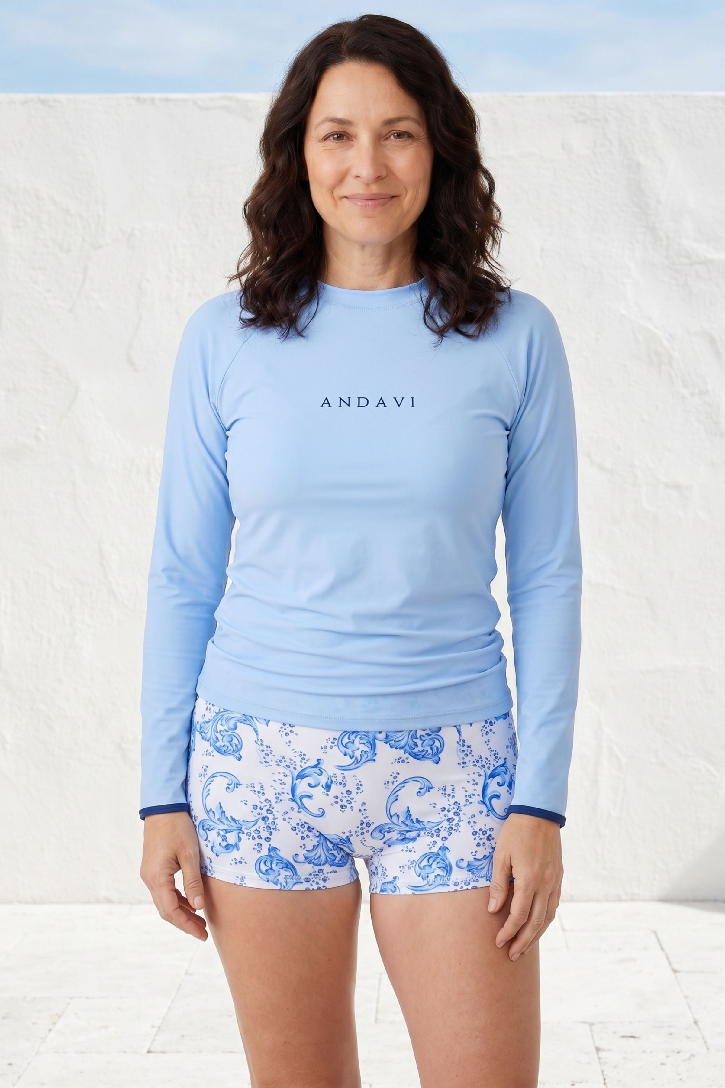 women wearing light blue andavi rash guard and blue and white swim shorts