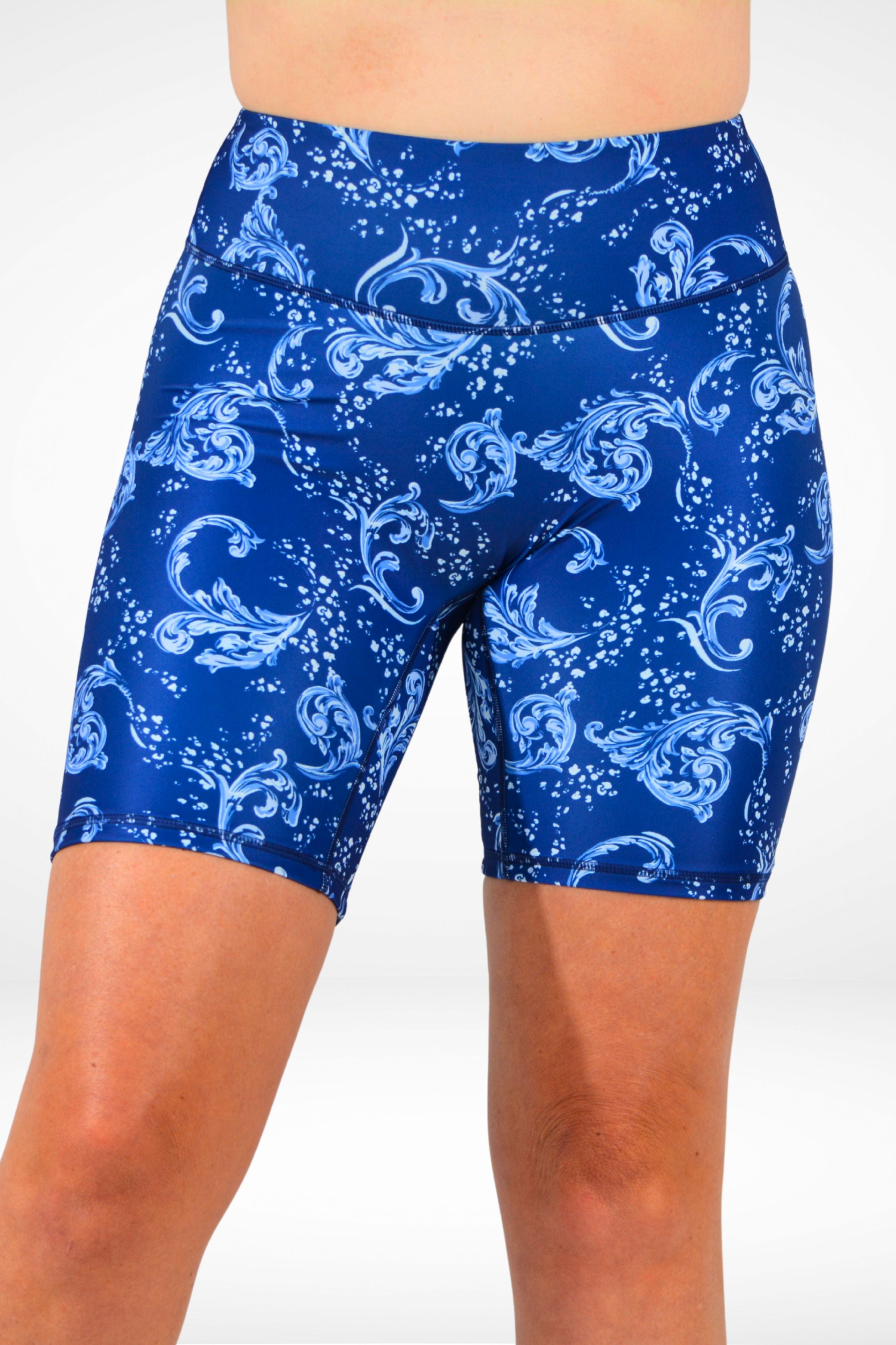Blue shorts with white floral pattern worn by a person on a white background