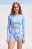 women wearing long sleeve crop rashie light blue and white and light blue pattern swim shorts