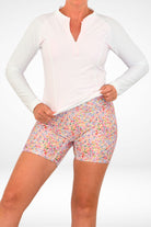 model wearing andavi long sleeve white upf50 rash guard and floral swim active bike short