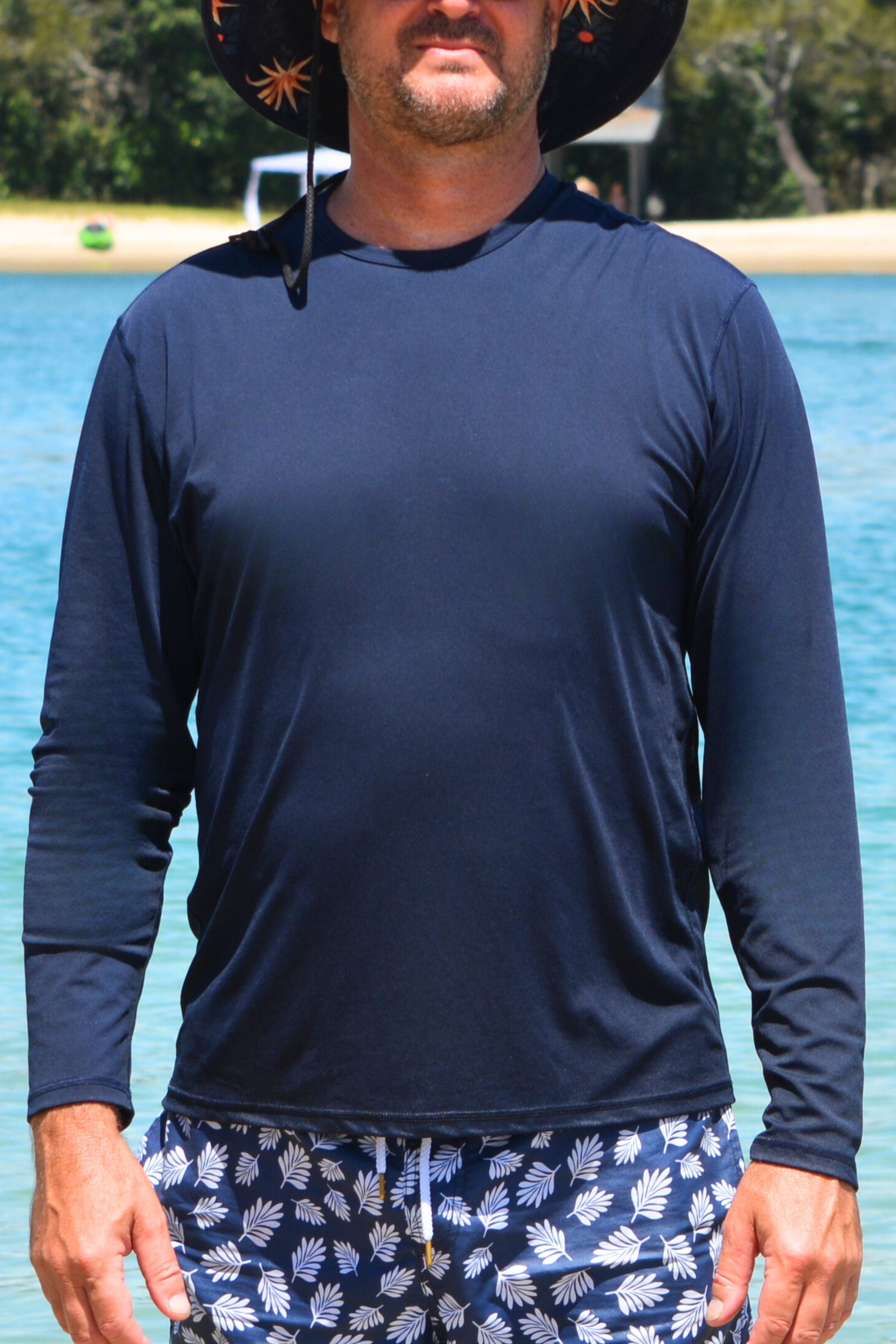 man wearing andavi long sleeve navy blue rash guard at the beach