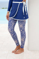Person wearing a blue outfit with a patterned design by a poolside.