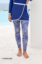 Woman wearing a blue and white patterned two-piece swimsuit by a pool.