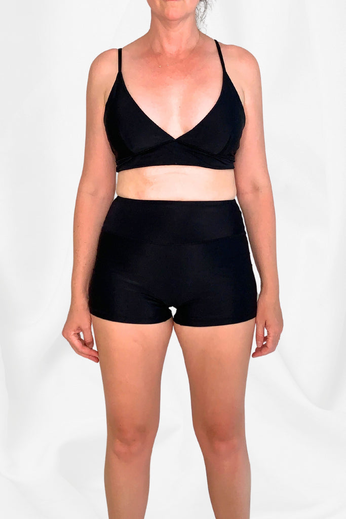women wearing black triangle bikini top and black swim shorts
