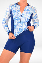 women wearing long sleeve blue and white print rash guard and navy blue modest style swim shorts 